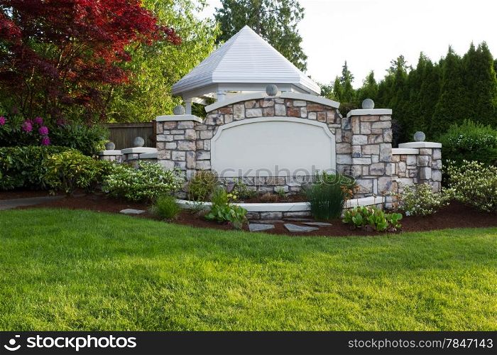 Horizontal evening front view photo of a new white pavilion surround by evergreens, Japanese Red Maple tree and rhododendron flowers in full bloom