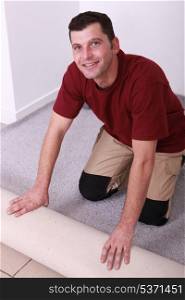 Horizontal image of a man laying carpet