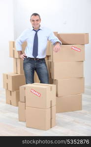 Horizontal image of a man surrounded by cardboard