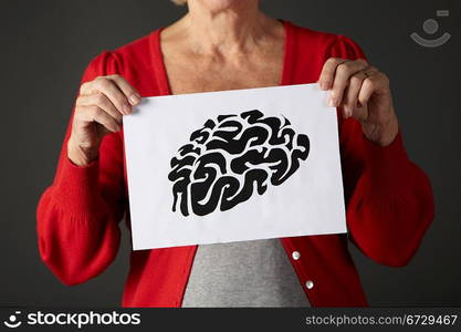 horizontal,indoors,studio shot,black background,holding,drawing,ink,brain,mental,health,agility,healthy,wellness,wellbeing,illness,alzheimers,dementia,casual clothing,mid section,front view,shadow,people,one person,female,woman,caucasian,adult,60s,sixties,senior,older,mature,retired,retirement,cropped