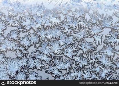 horizontal natural background - blue frozen ice on surface on home window glass close up on cold winter day