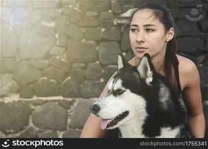 Horizontal outdoors portrait of young woman embracing her dog.. Portrait of woman with dog