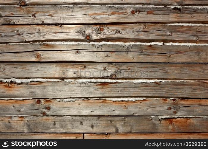 Horizontal parallel old wooden logs with heat insulation material between them. Part of wooden house walls