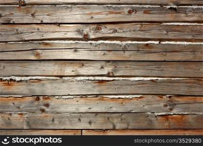 Horizontal parallel old wooden logs with heat insulation material between them. Part of wooden house walls