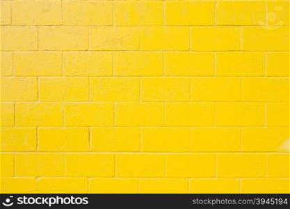 horizontal part of bright yellow painted brick block wall