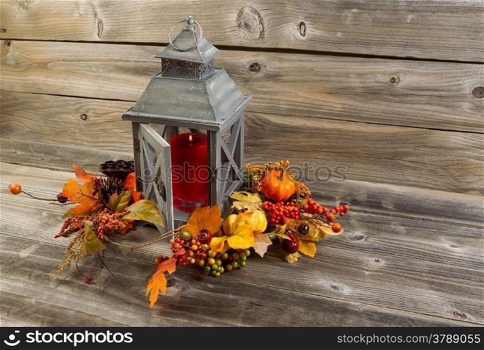 Horizontal photo of an old Asian design lantern with red candle burning inside on rustic wood