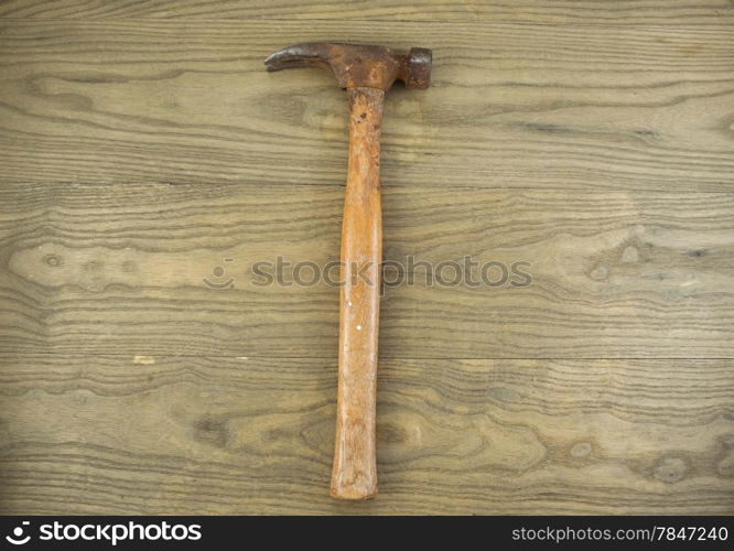 Horizontal photo of an old claw hammer on aged wood