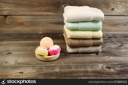 Horizontal photo of clean stacked towels and cleaning products in small dish on rustic wood