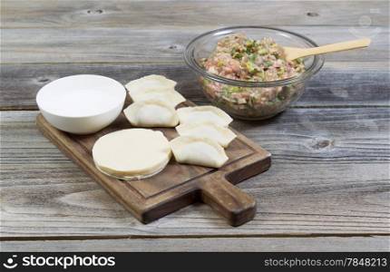 Horizontal photo of homemade traditional Chinese Dumplings being made from raw ingredients