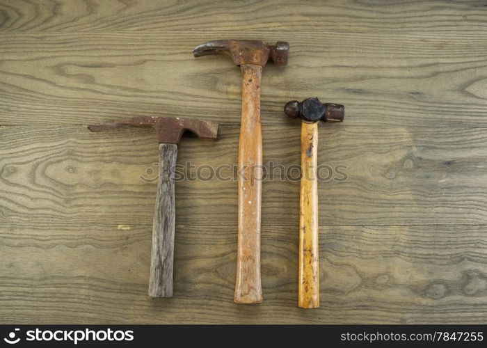 Horizontal photo of old masonry, claw and ball peen hammers on aged wood