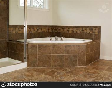 Horizontal photo of soaking tub in master bathroom with partial shower and windows