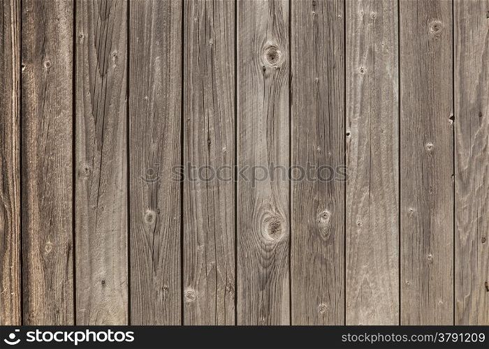 horizontal picture of old grey vertical planks with fading brown paint