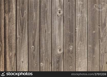 horizontal picture of old grey vertical planks with fading brown paint