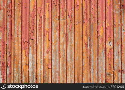 horizontal picture of old grey vertical planks with fading red and orange paint