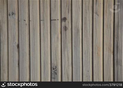 horizontal picture of old grey vertical planks with peeling beige and brown paint