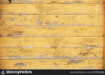 horizontal picture of old horizontal planks with peeling yellow paint