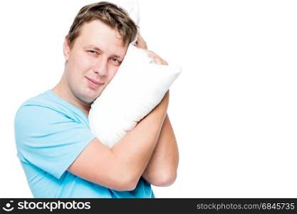Horizontal portrait of 30 year old man with pillow on white back. Horizontal portrait of 30 year old man with pillow on white background