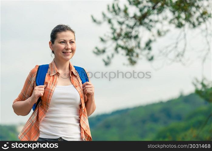 horizontal portrait of a beautiful brunette with a backpack on n. horizontal portrait of a beautiful brunette with a backpack on nature in a hike