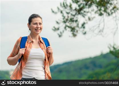 horizontal portrait of a beautiful brunette with a backpack on n. horizontal portrait of a beautiful brunette with a backpack on nature in a hike