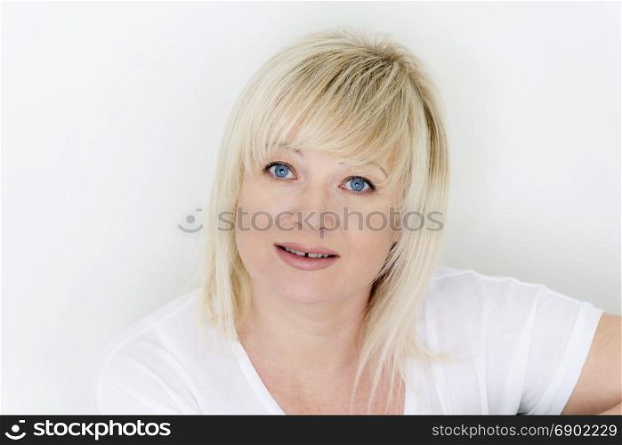 Horizontal portrait of blond woman with blue eyes in white