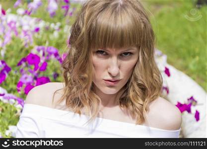 Horizontal portrait of talking woman with blond hair on flowers background