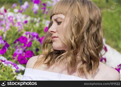 Horizontal portrait of young serious woman on flowers background