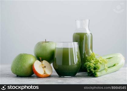 Horizontal shot of freshly blended apples and cerely for your healthy eating. Vegetarian green drink in glasses. Detox beverage, fruits and vegetable around