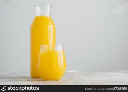 Horizontal shot of freshly squeezed orange juice made of citrus in glass containers, isolated over white background with blank space