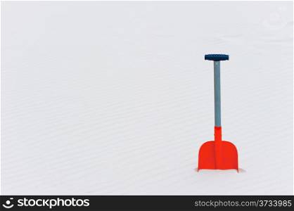 horizontal shot of orange shovel in the sand