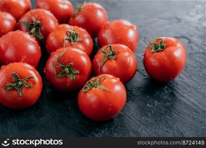 Horizontal shot of red fresh tomatoes harvested for making vegetable salad. Healthy eating and vitamins concept. Juicy organic tomatos