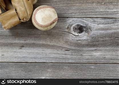 Horizontal top view angle of old baseball and weathered leather mitt on rustic wood