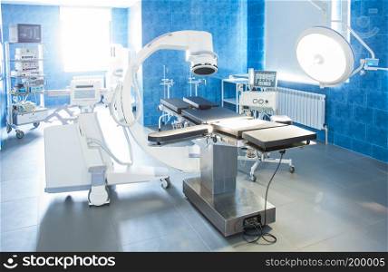 Horizontal view of modern operating room with X-ray medical scan, equipment and medical devices. Bright backlight.