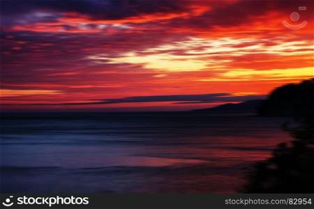 Horizontal vivid red orange vibrant sunset ocean horizon motion abstraction background backdrop. Horizontal vivid red orange vibrant sunset ocean horizon motion