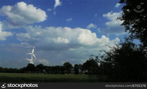 Horizontaler Schwenk von rechts nach links nber ein Getreidefeld auf einen Windpark mit mehreren Anlagen in Niedersachsen, Deutschland.