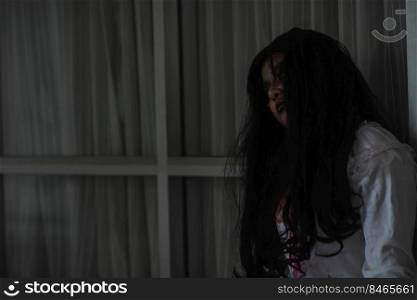 Horror evil woman ghost creepy in a dark room at house. The female devil is scary she haunted at the abandoned building, Happy Halloween day concept 