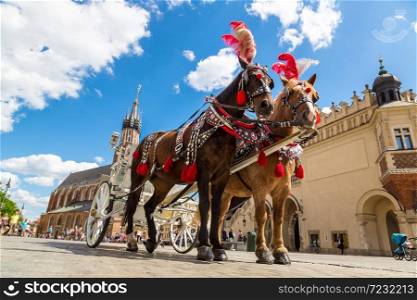 Horse carriages at main square in Krakow in a beautiful summer day, Poland
