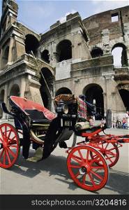Horse drawn carriage in front of a colosseum, Rome, Italy