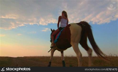 Horseback riding to the horizon at sunset