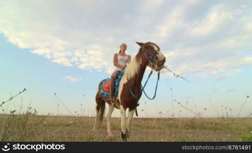 Horseback riding vacations girl rider with her horse in the field