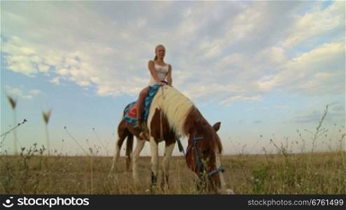 Horseback riding vacations girl rider with her horse in the field