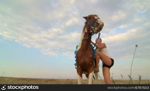 Horseback riding vacations girl rider with her horse in the field