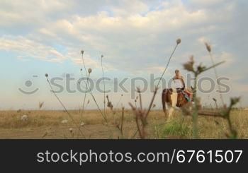 Horseback riding vacations girl rides horse away in field