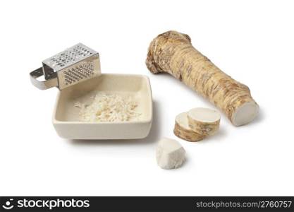 Horseradish and grater on white background