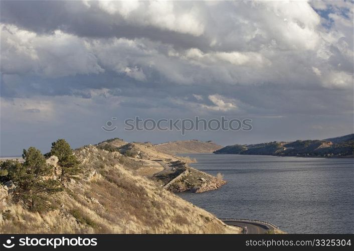 Horsetooth Reservoir with Centennial highway near Fort Collins, Colorado, high wind conditions and heavy clouds in early spring