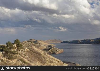 Horsetooth Reservoir with Centennial highway near Fort Collins, Colorado, high wind conditions and heavy clouds in early spring