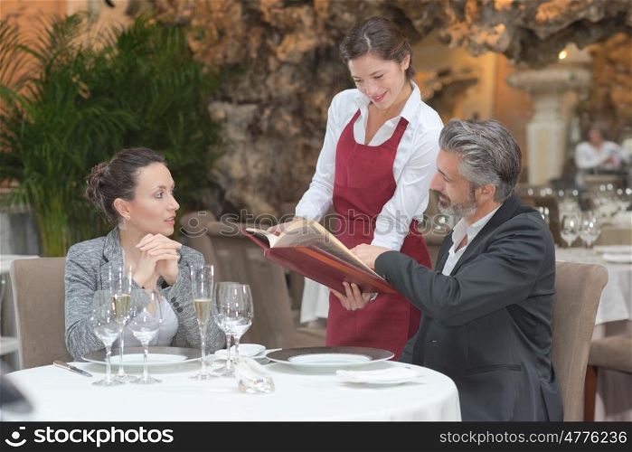 hospitable waitress taking couples order in gastronomy restaurant