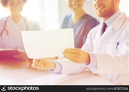 hospital, cardiology, people and medicine concept - close up of happy doctors looking at cardiogram at medical office