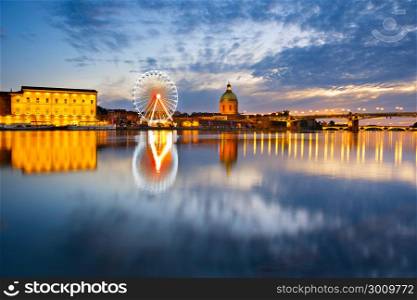 Hospital de La Grave and Ferries Wheel reflected in Garone river. Toulouse, France