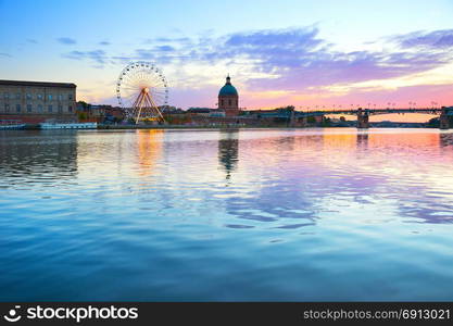 Hospital de La Grave and Ferries Wheel reflected in Garone river. Toulouse, France