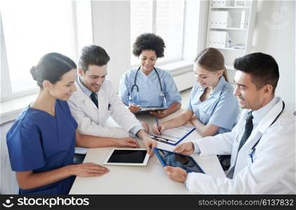 hospital, medical education, health care, people and medicine concept - group of happy doctors with tablet pc computers meeting at medical office